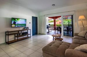 ein Wohnzimmer mit Couch und Flachbildfernseher in der Unterkunft Chico's Seru Hulanda Resort in Willemstad