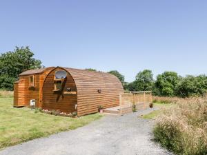 um grande celeiro de madeira sentado num campo em Embden Pod at Banwy Glamping em Welshpool