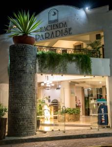 a store front with a potted plant in front of it at Hacienda Paradise Hotel in Playa del Carmen