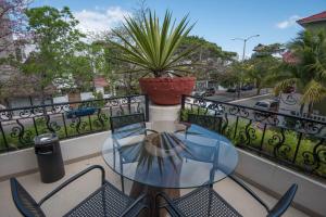 een glazen tafel en stoelen op een balkon bij Hacienda Paradise Hotel in Playa del Carmen