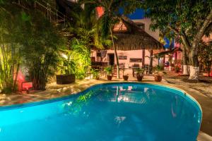 a swimming pool in front of a house at Hacienda Paradise Hotel in Playa del Carmen