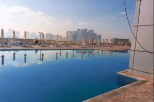 a large pool of water with a city in the background at 2 bedroom luxury beach apartment with Full seaView in Ajman 