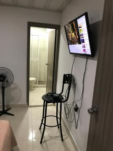a room with a chair and a flat screen tv at confort 3 in Cali