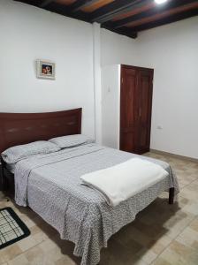 Un dormitorio con una cama con una manta. en Estancia Puerto López, en Puerto López