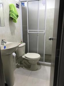 a bathroom with a toilet and a sink and a shower at confort 3 in Cali