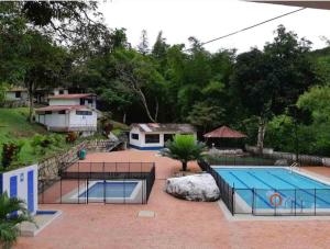 a swimming pool in a yard with a house at Eco Hotel Entre Ríos in Villeta