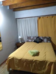 een slaapkamer met een bed met een gele deken bij Santa Clara in Santa Clara del Mar