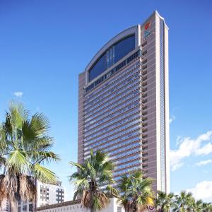 a tall building with palm trees in front of it at Hotel Keihan Universal Tower in Osaka