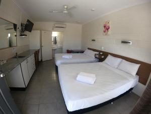 
A bed or beds in a room at Coolabah Motel Townsville
