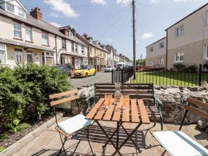 une table et des chaises en bois dans une rue avec des maisons dans l'établissement Kooky Cottage, à Brecon