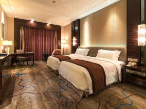 Habitación de hotel con 2 camas y escritorio en Shenzhen Baohengda International Hotel, en Longgang