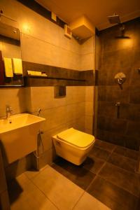 a bathroom with a toilet and a sink at Zubis Inn Hotel in Kalpetta