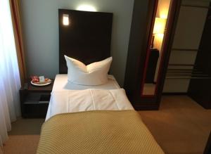 a bedroom with a bed and a mirror at DämeritzSeehotel in Berlin