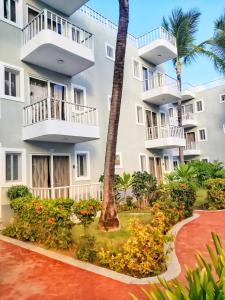 um edifício de apartamentos com varandas e uma palmeira em Punta Cana Sol Caribe Beach Pool em Punta Cana