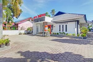- un bâtiment blanc avec un panneau rouge dans l'établissement Hotel Shafira Pariaman Syariah Mitra RedDoorz, à Pariaman