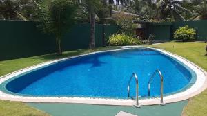 una gran piscina azul en un patio en Villa Carla en Balapitiya