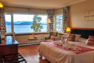 a hotel room with a bed and a large window at Sol del Nahuel - Hotel & Spa in San Carlos de Bariloche