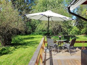 a patio with a table and chairs and an umbrella at 4 person holiday home in HEMSE in Hemse
