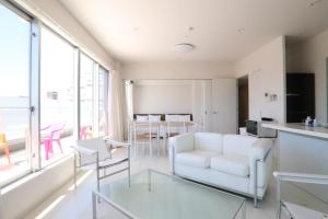 a living room with a white couch and tables at PG Kuromon in Osaka