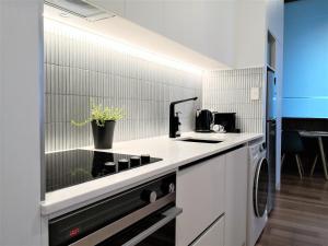 a kitchen with a stove and a dishwasher at Private apartments in a Landmark Heritage Building in Auckland