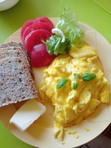 une assiette de nourriture avec des œufs, du pain et des légumes dans l'établissement Agroturystyka Janiczek Tuchów, à Dąbrówka Tuchowska