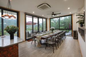 une grande salle à manger avec une longue table et des chaises dans l'établissement Villa Tam Dao Golf & Resort Luxury, à Yen