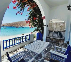 a table and chairs on a balcony with a view of the beach at Family house by the seaside of Karavostasis in Karavostasi