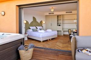 利勒鲁斯Hôtel & Spa Rocabella的一间带床的卧室和一间带镜子的浴室