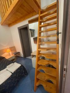 ポンツァにあるB&B La Terrazza Sul Portoのベッドルーム1室(ベッド1台付)に階段を利用する部屋1室