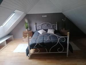 een slaapkamer met een metalen bed op zolder bij Gîte le parc Michel in Roz-sur-Couesnon