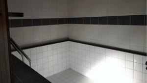 an empty bathroom with a staircase in a tiled room at Penzion Athéna - sportovní areál in Nová Včelnice