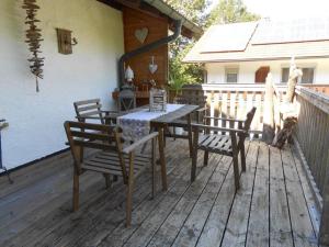 a wooden deck with a table and chairs on a house at Ferienwohnung Mayer in Waging am See