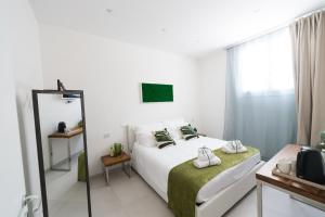 una camera bianca con letto e specchio di Family Green Suite a Marsala