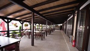 a patio with tables and chairs in a restaurant at Pensiunea Mirific in Dubova