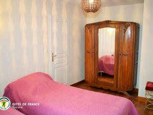 - une chambre avec une armoire en bois et un lit rose dans l'établissement Gîte Cangey, 4 pièces, 6 personnes - FR-1-381-82, à Cangey