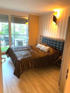 a bedroom with a large bed and a balcony at Silver Gellért Apartman in Siófok