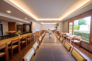 a room with a row of benches and tables at Huen Jao Ban Hotel in Chiang Mai