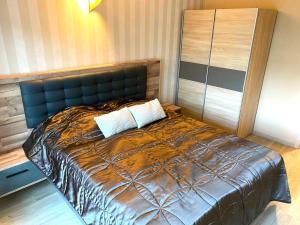 a bed with two pillows on it in a room at Silver Gellért Apartman in Siófok