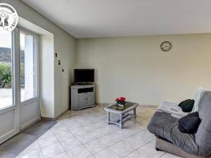 a living room with a couch and a tv at Studio Planfoy, 1 pièce, 2 personnes - FR-1-496-134 in Planfoy