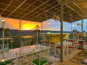 a restaurant with tables and chairs with a sunset in the background at Our Story Boutique Hotel in Cagayan de Oro