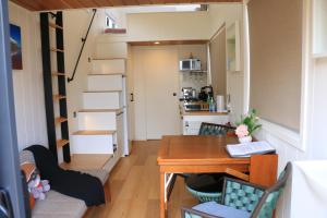 a tiny house with a table and chairs and a staircase at The Pink Lake Tiny House - 'Sakura' in Lochiel