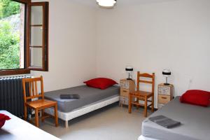 - une chambre avec 2 lits, 2 chaises et une fenêtre dans l'établissement Gîte d'étape Chez François, à Conques