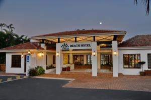 un hôtel situé à l'avant d'un immeuble avec un parking dans l'établissement Pumula Beach Hotel, à Umzumbe
