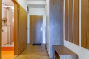 un pasillo con un banco de madera y una puerta en Lipno View - Blue Apartment 6, en Lipno nad Vltavou