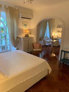 a bedroom with a white bed and a dining room at Casa Nenna, centro di Forio in Ischia