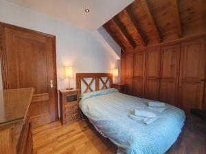 a bedroom with a bed with wooden cabinets and a desk at Dúplex Mirador de Potes - 4 pax, con Wifi y Garaje in Camaleño