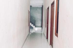 アンボンにあるAlmira Homestay Ambon Mitra RedDoorzの階段と階段がある空の廊下