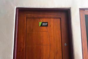 uma porta de madeira com um sinal em Almira Homestay Ambon Mitra RedDoorz em Ambon