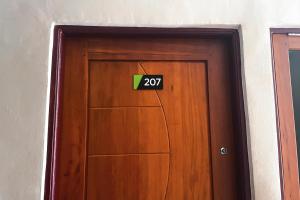 een houten deur met een bord erop bij Almira Homestay Ambon Mitra RedDoorz in Ambon