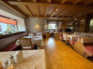 ein Restaurant mit Tischen und Stühlen in einem Zimmer in der Unterkunft Hotel Garnì Savoy in Kastelruth